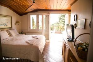 a bedroom with a bed and a television in it at Villa da Esperança in Campos do Jordão