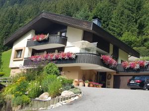 ein Haus mit Blumen und Pflanzen davor in der Unterkunft Haus Güatli in Gaschurn