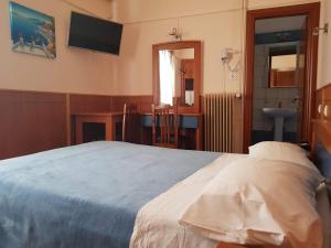 sypialnia z łóżkiem, biurkiem i telewizorem w obiekcie Hotel Ionion w mieście Kyllini