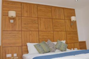 Schlafzimmer mit einem Bett mit einem großen Kopfteil aus Holz in der Unterkunft Sunset Bay Apartment in Glacis