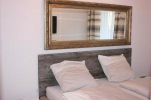 una camera con specchio sopra un divano e cuscini di APARTAMENT MANIA a Giżycko