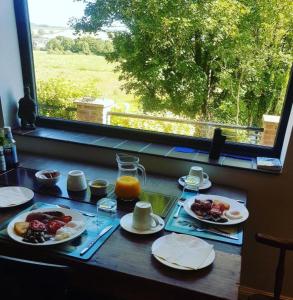 a table with plates of breakfast food and a window at Waterfield House B&B in Dorchester