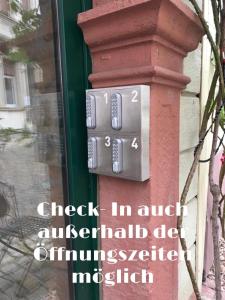 un reloj en una columna en un edificio en Ferienwohnung Hotel Glockenhof, en Eltville am Rhein