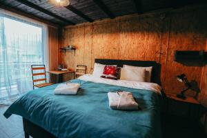 1 dormitorio con 1 cama grande y 2 toallas. en Wooden Hotel Kazbegi, en Kazbegi