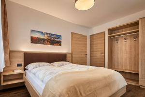 - une chambre avec un grand lit dans l'établissement Saina, à Colfosco