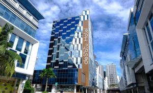 a tall building with a sign that reads hotel corazon at Desatu Hotel in Medan