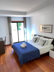 een slaapkamer met een groot bed met een blauwe deken bij Luz Beach Luxury Apartment in Luz +52 foto's