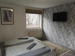 a bedroom with two beds and a tv on a wall at Jonas Apartment in Winterberg