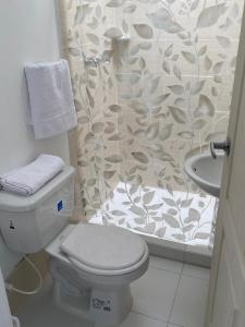 a bathroom with a white toilet and a shower at Hostal Mochileros Inn in Circasia