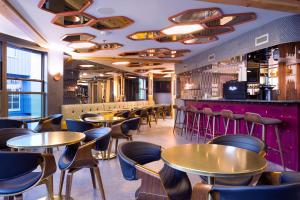 a restaurant with tables and chairs and a bar at Pangea Pod Hotel in Whistler
