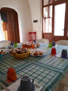 einen Tisch mit einem Tischtuch mit Essen drauf in der Unterkunft Masseria Cassiere in Mottola