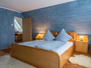 een slaapkamer met een bed met een blauwe muur bij Wohlfühlen in Ostseenähe in Ratekau