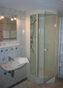 uma casa de banho com um chuveiro e um lavatório. em Gästehaus Eckstein em Oy-Mittelberg