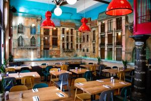 ein Restaurant mit Holztischen und -stühlen und roten Lichtern in der Unterkunft Hotel Doria in Amsterdam