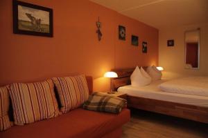 ein Hotelzimmer mit 2 Betten und einem Sofa in der Unterkunft Gästehaus Eckstein in Oy-Mittelberg