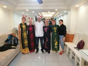 um grupo de pessoas posando para uma foto em um quarto em Roma Hotel Noi Bai airport em Hanói