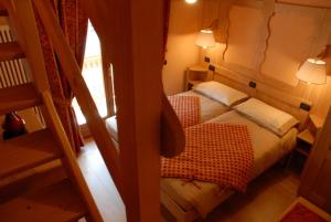 een kleine kamer met 2 bedden en een trap bij Affittacamere Lou Ressignon in Cogne