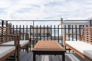 a balcony with two benches and a table on a roof at Appartement 4 étoiles vue mer et bord de plage Chez Odette in Saint Malo