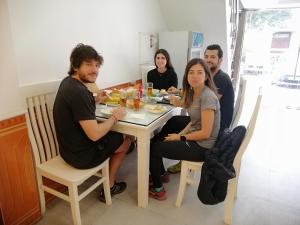 un grupo de personas sentadas alrededor de una mesa comiendo comida en Roma Hotel Noi Bai airport, en Hanói