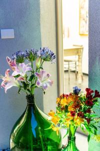 two green vases filled with flowers on a table at Benaco36 in Torri del Benaco