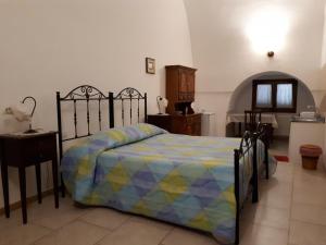 una camera da letto con un letto con un piumone colorato di Masseria Cassiere a Mottola