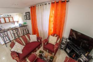 a living room with two chairs and a flat screen tv at Posada Caribbean Refuge in San Andrés