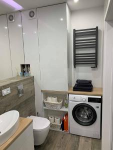 uma casa de banho com uma máquina de lavar roupa e um WC em Prestige Line Apartament em Legnica