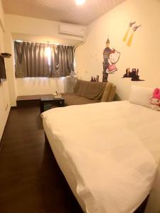 1 dormitorio con 1 cama blanca grande y 1 sofá en 逢甲朵拉, en Taichung