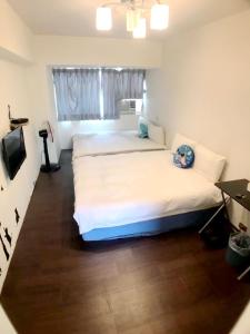 a bedroom with two beds and a television in it at 逢甲朵拉 in Taichung
