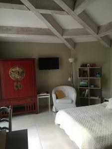 EyraguesにあるLe Clos Martinのベッドルーム(ベッド1台、椅子、テレビ付)