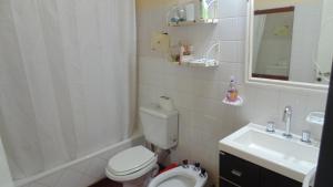 a bathroom with a toilet and a sink at Casa Las Calas in Puerto Madryn