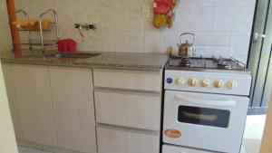 a kitchen with a white stove and a sink at Casa Las Calas in Puerto Madryn +25 photos