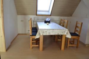 einen Esstisch mit Stühlen und ein Fenster in der Unterkunft Ferienwohnung im Alten Zollhaus in Kurort Oberwiesenthal