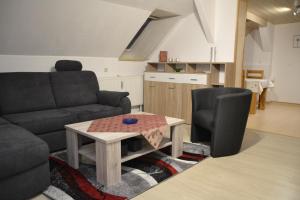 クアオルト・オーバーヴィーゼンタールにあるFerienwohnung im Alten Zollhausのソファとテーブルのあるリビングルーム +8枚の写真