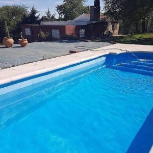 una gran piscina azul frente a una casa en 7 colores en Córdoba