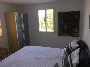 1 dormitorio con cama blanca y ventana en Le Voltigeur du Ventoux, en Entrechaux