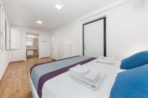 een witte slaapkamer met een groot bed met blauwe kussens bij Casa da Suite Diodora in Milaan