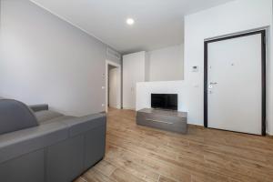 een woonkamer met een bank, een tv en een spiegel bij Casa da Suite Diodora in Milaan