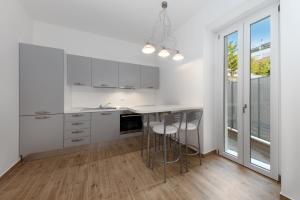 een keuken met witte kasten en een tafel met krukken bij Casa da Suite Diodora in Milaan