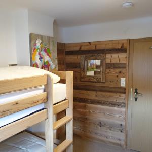 Zimmer mit 2 Etagenbetten und einer Holzwand in der Unterkunft Haus Walchen in Piesendorf