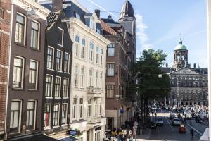 a city street with buildings and people walking on the street at Hotel Doria in Amsterdam