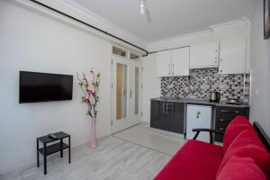 a living room with a red couch and a kitchen at Arney Suites in Eskisehir