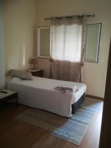 um quarto com uma cama branca e uma janela em Cc39- Q5 no Funchal