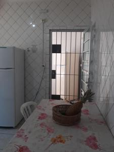 a kitchen with a table with a basket on it at Aconchegante casa para temporada in Mongaguá +13 photos