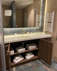 a bathroom with a sink and a mirror and towels at Teddy Apartman Kula Konaci in Kopaonik +25 photos