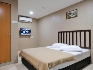 a bedroom with a bed and a tv on the wall at Hotel Nawar in Pasir Mas