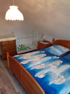 a bedroom with a bed with a blue blanket with sheep on it at Ferienhof zur alten Linde in Holtgast