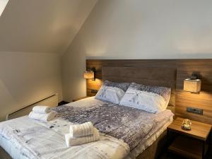 a bedroom with a large bed with two towels on it at Teddy Apartman Kula Konaci in Kopaonik