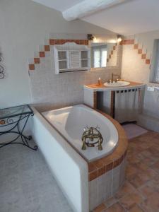 ein Badezimmer mit einer Badewanne und einem Waschbecken in der Unterkunft La Jubilotte in Beaumes-de-Venise