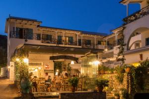 a building with people sitting outside of a restaurant at Odyssey Suites in Poros